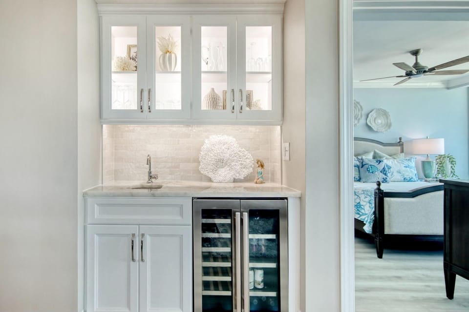 Chic wet bar with glass-front cabinets and wine fridge