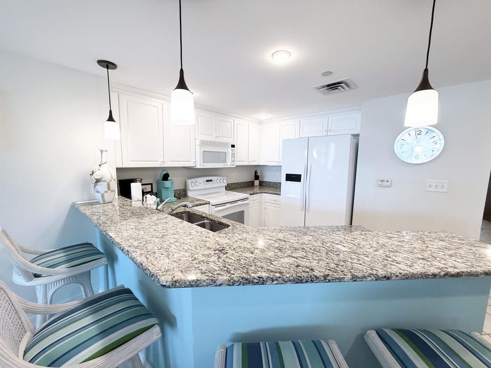 Bright kitchen with granite countertops and cozy breakfast bar seating