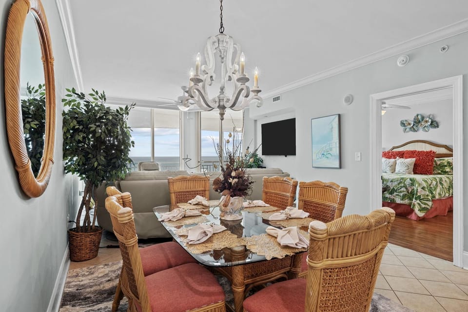 Sunlit dining room with cozy wicker seating and elegant chandelier