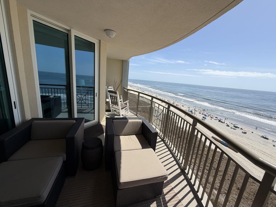 Spacious balcony with ocean views and cozy seating