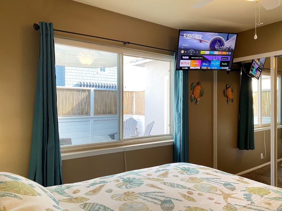 Third bedroom with TV, blackout curtains, mirrored closet and dresser drawers!
