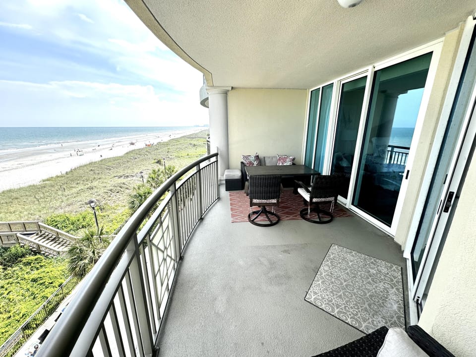 Oceanfront balcony with stunning beach views and cozy seating
