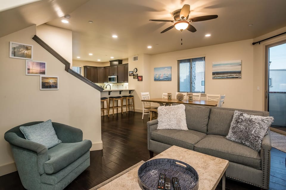 Living room, dining area and kitchen open space for friends and family to gather. Nearby is a sliding door leading to a balcony.