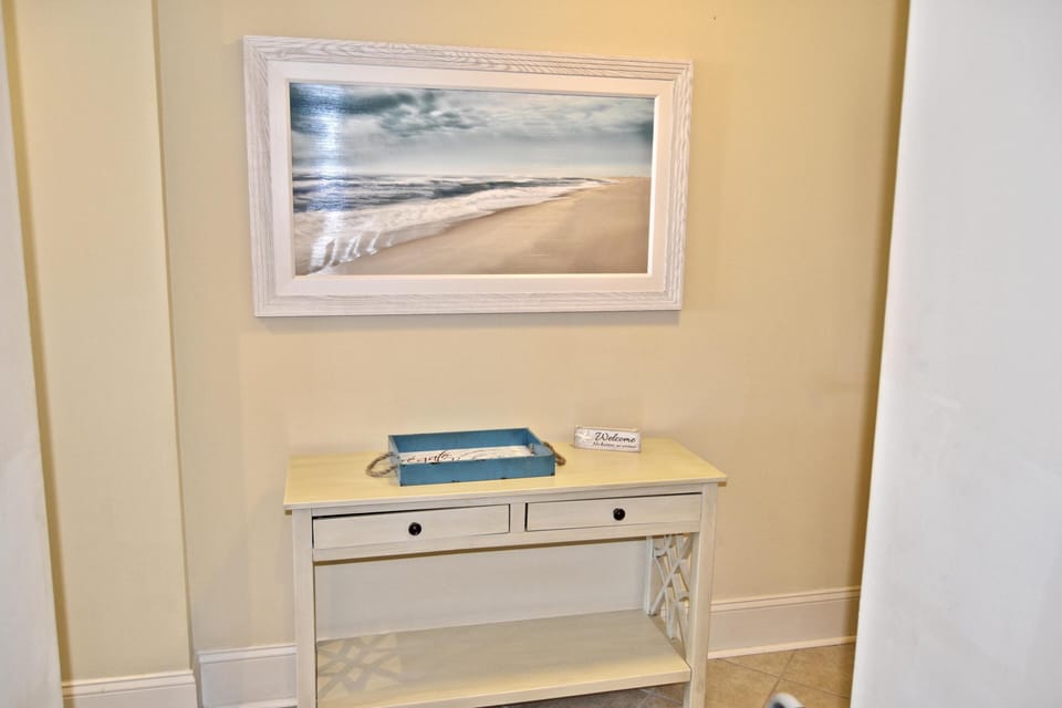 Cozy entryway with serene beach artwork and storage table