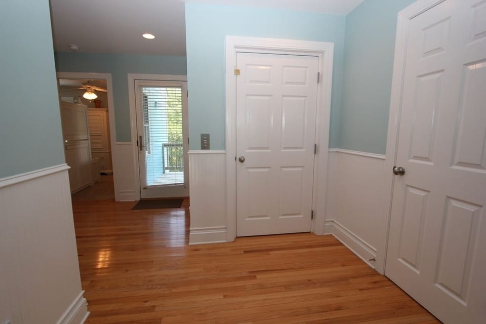 Step into your welcoming entryway with gleaming hardwood floors and soothing coastal blue walls that create an instantly calming atmosphere.