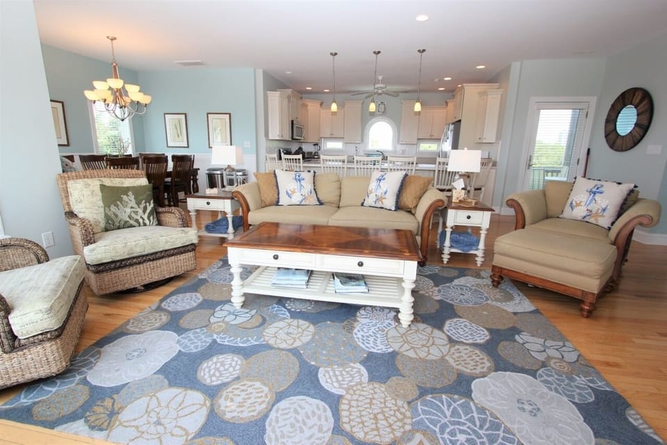 Relax in this open-concept living space where coastal charm meets comfort. Sink into plush seating while enjoying the seamless flow to your fully-equipped kitchen.