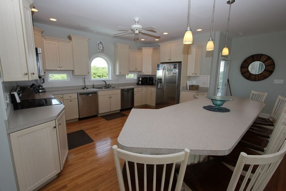 Your spacious kitchen invites culinary adventures with gleaming countertops, modern appliances, and warm wood floors that make cooking feel effortless.