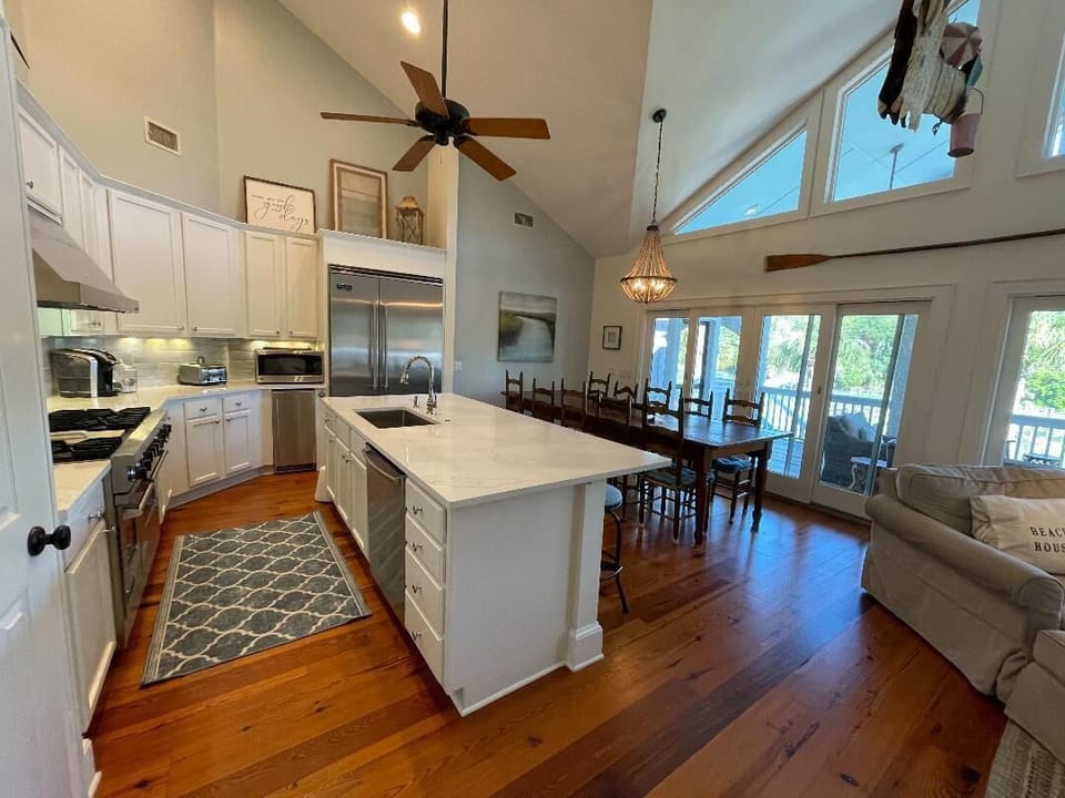 Newly renovated chef's kitchen with big quartz island and large farm table.