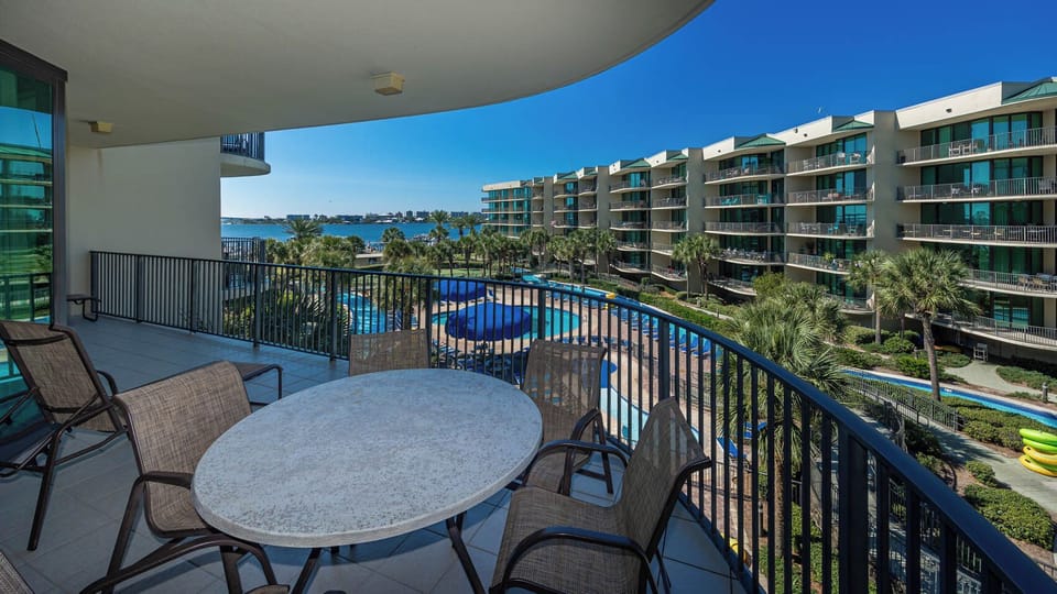 Savor the coastal breeze while lounging at the table, taking in the vibrant pool and bay views below