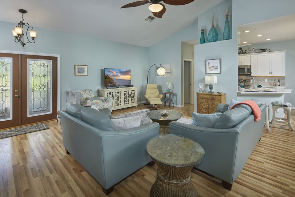 Living room with leather furniture and smart TV.