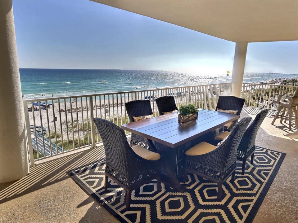 Spacious balcony deck dining overlooking the water and directly on the beach.