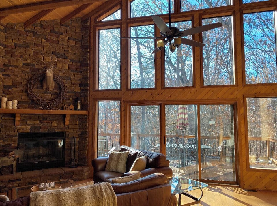 Main entertainment room with vaulted ceiling and glass window wall with a view