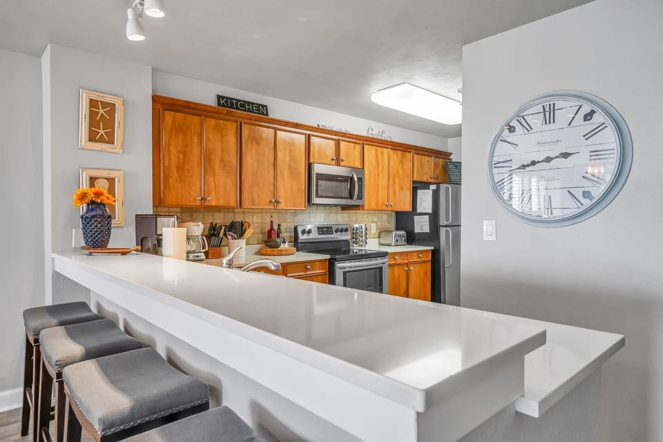 Fully stocked kitchen overlooks the living room with views of the sparkling emerald coast.