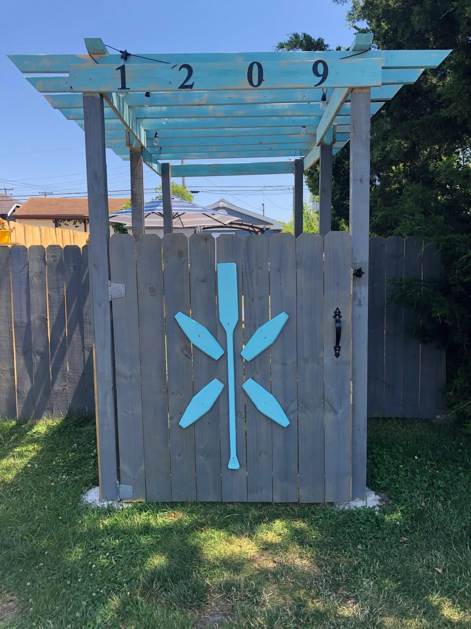 Fully fenced in yard with custom pergola entrance.