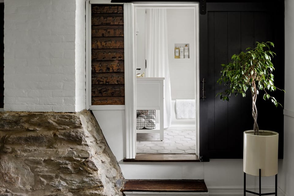 Custom barn door leads to en suite bathroom in "cabin" bedroom