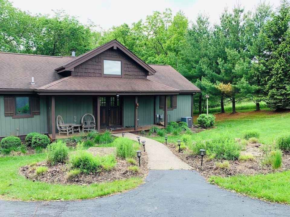 This inviting home offers a comfortable porch, clean landscaping, and a quiet natural setting that guests appreciate for restful vacations.