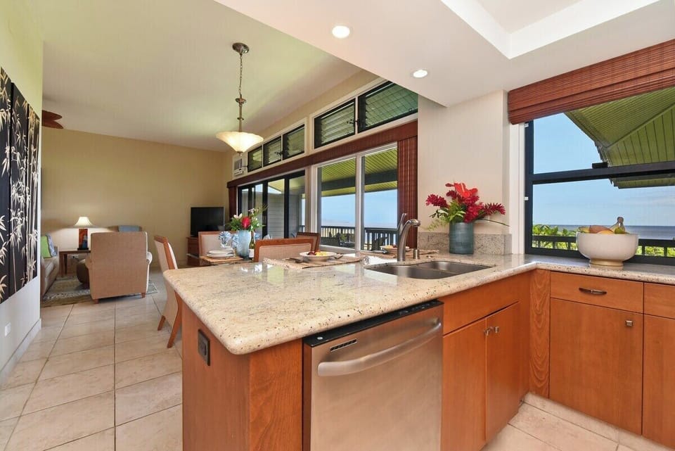 Alternate kitchen view showcasing ample counter space, wood cabinetry, and open sightlines to the living area.