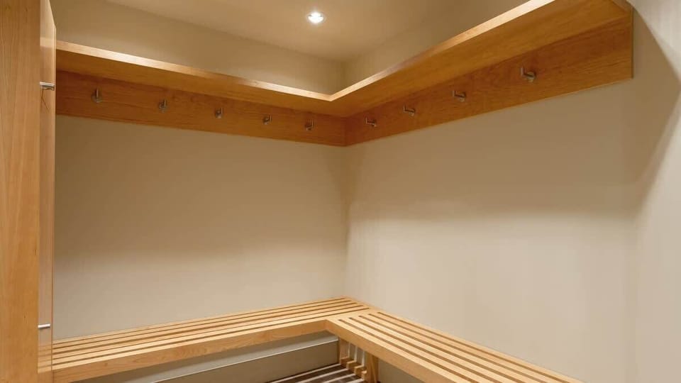 - Mudroom-style entry with built-in wooden benches and coat hooks  
- Perfect space for storing ski gear, boots, and outdoor essentials  
- Functional design for easy transitions from slope to suite comfort  
