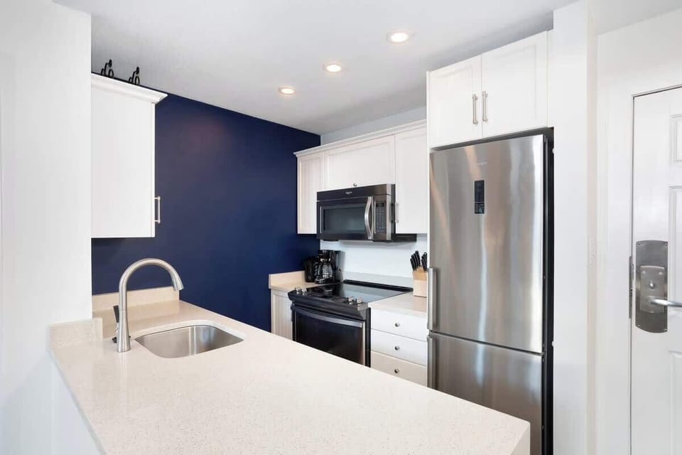 - Sleek kitchen with stainless steel appliances and deep blue accent wall  
- Fully equipped for home-style meals after Whistler adventures  
- Bright countertops and modern fixtures for easy meal prep and cleanup  
