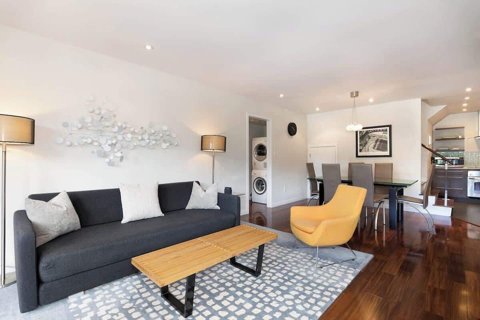 Cozy living room scene w/ patterned rug, warm wood coffee table, and relaxed seating to unwind.