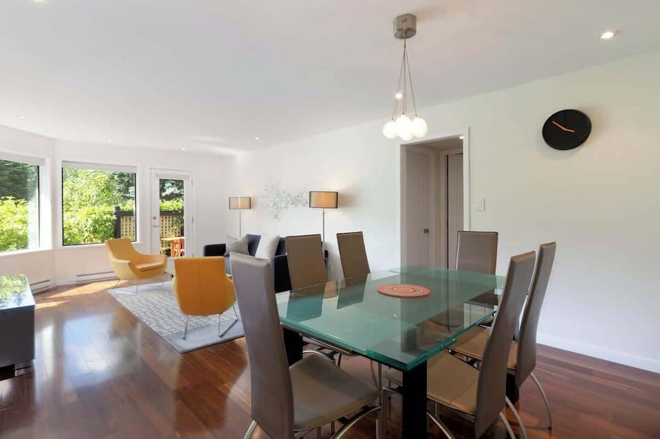 Airy dining space w/ a glass table and modern chairs, ideal for shared meals and easy conversation.
