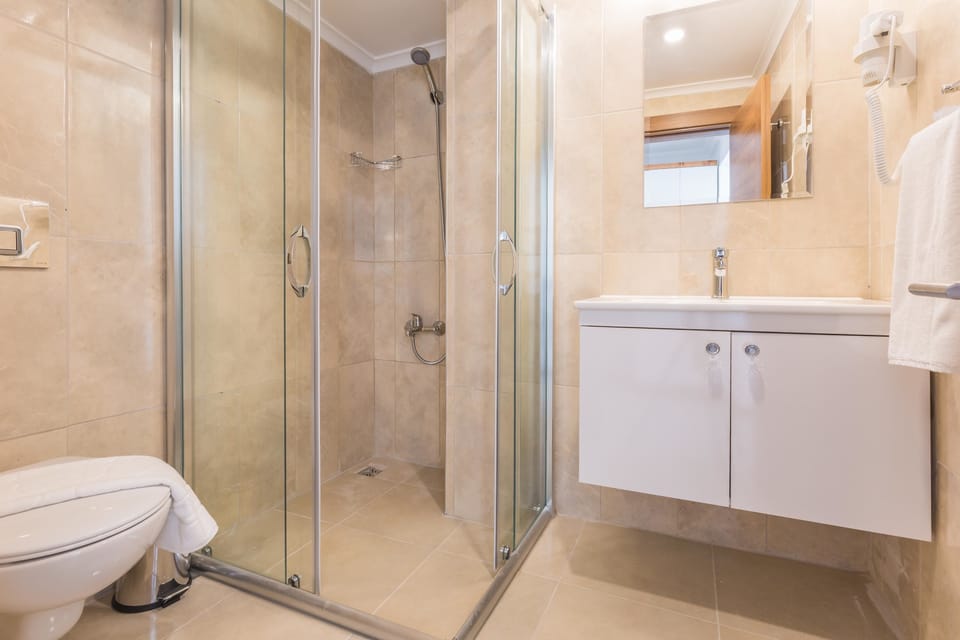 Standard Triple Room, Partial Sea View | Bathroom | Shower, hair dryer, slippers, towels