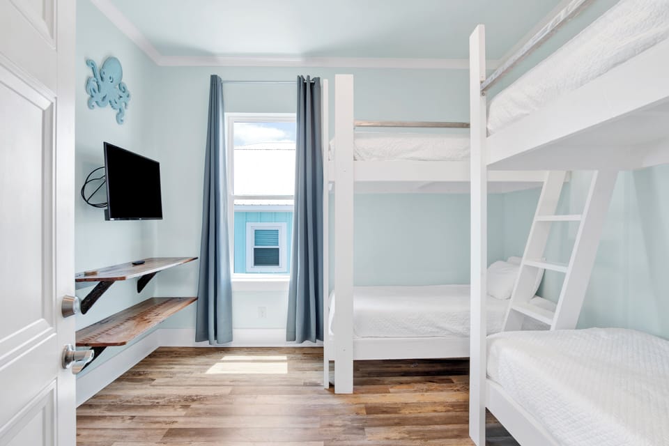 Bedroom 4 offers 2 sets of twin bunk beds, a TV and attached, shared bathroom