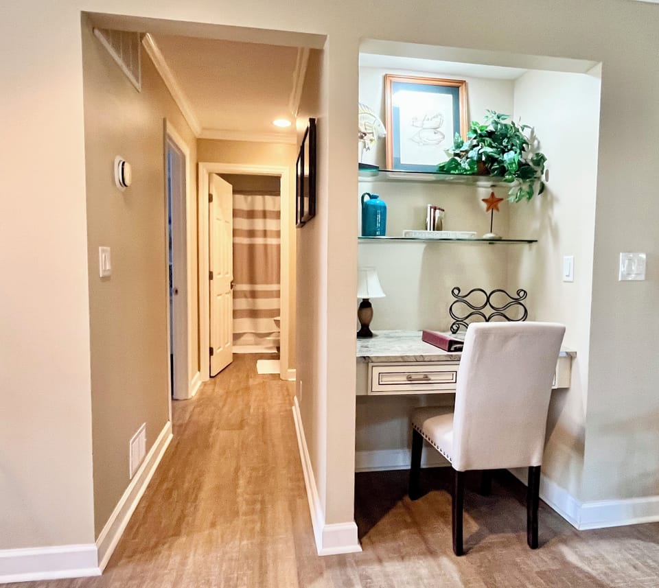 Desk in living room and hallway to guest bathroom.