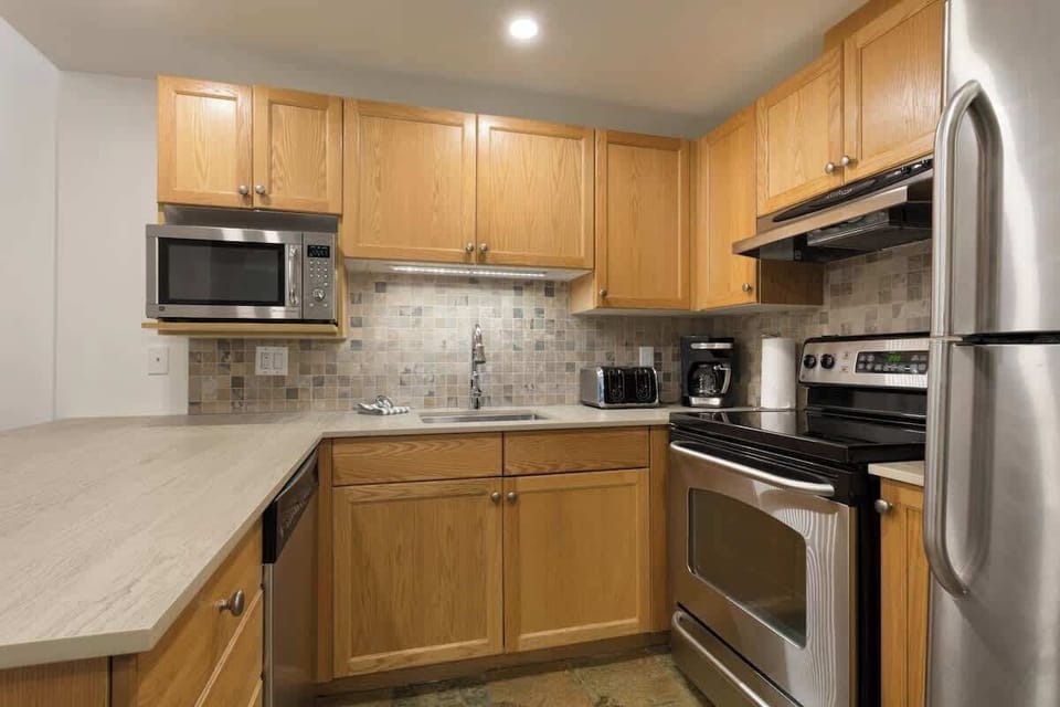 - Fully equipped kitchen with stainless steel appliances and wooden cabinetry  
- Cook home-style meals with ease using modern conveniences  
- Perfect for après-ski dining or cozy breakfasts indoors  
