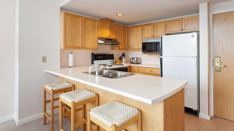 - Fully equipped kitchen with wooden cabinetry and breakfast bar seating  
- Stainless appliances and essentials for home-style mountain meals  
- Open layout ideal for gathering after a day of skiing or exploring Whistler  
