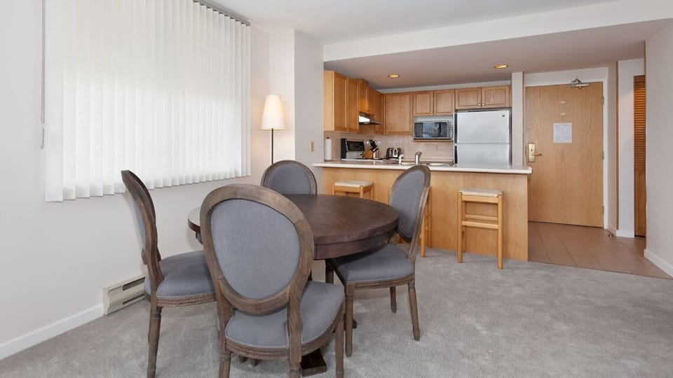 - Open dining area beside a bright full kitchen for home-style meals  
- Modern setup with wooden finishes and comfy seating for family gatherings  
- Perfect for shared breakfasts before hitting the Whistler slopes 