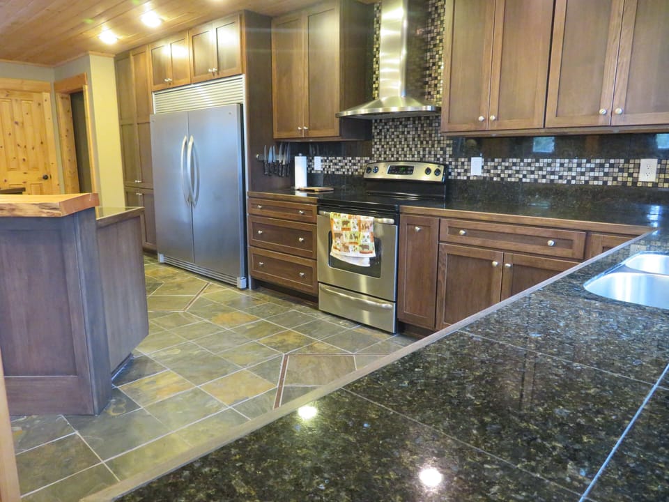 Gourmet kitchen with granite countertops with large refrigerator-freezer