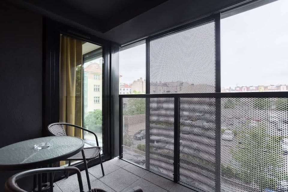 Furnished balcony with green surroundings. 