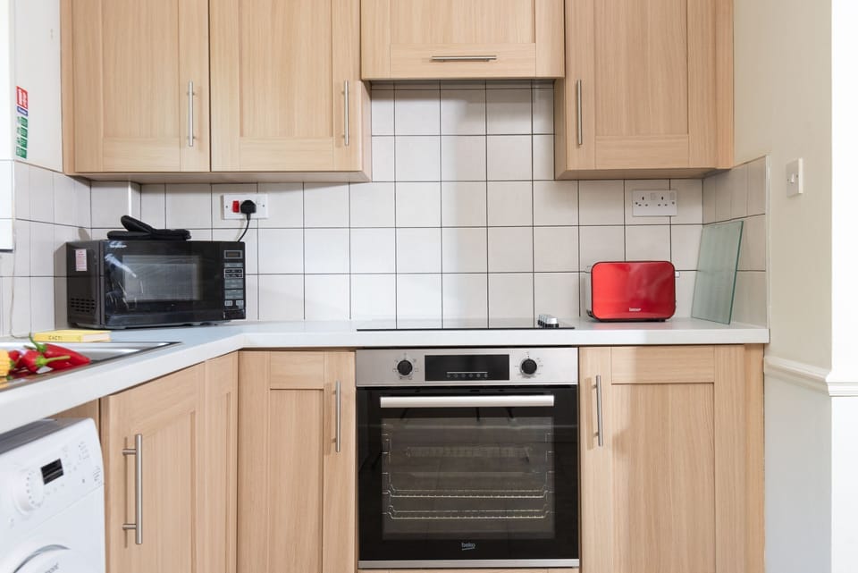 Kitchen utensils and an oven, microwave, hob and toaster - Nobbys Cottage