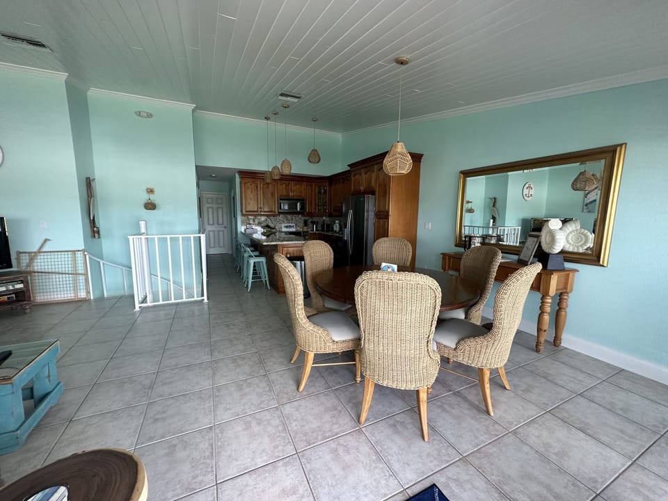 Upstairs living area with kitchen, dining table and outdoor balcony. 