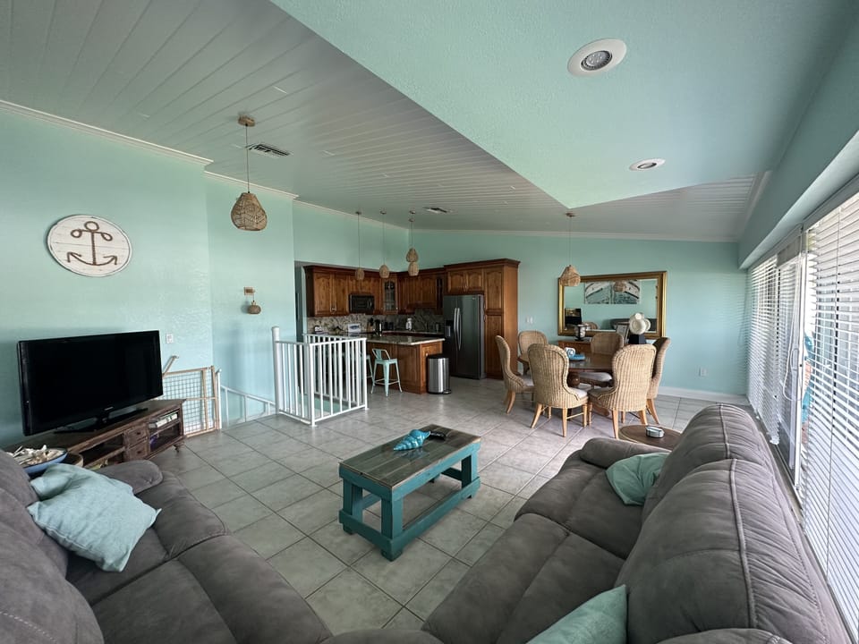 Upstairs living area with kitchen, dining table and outdoor balcony. 