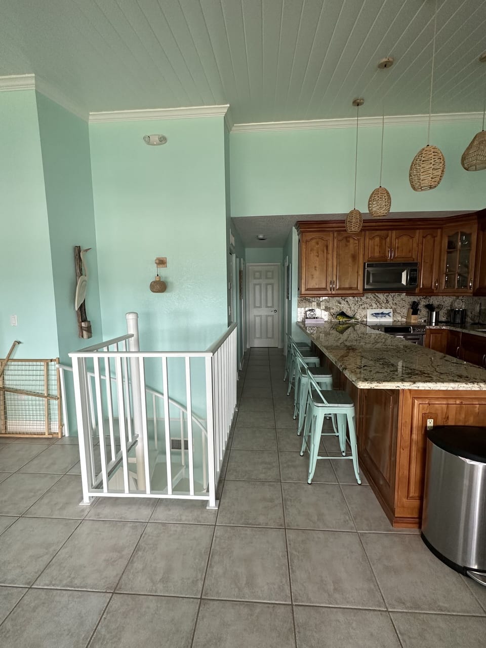 Upstairs living area with kitchen, dining table and outdoor balcony.