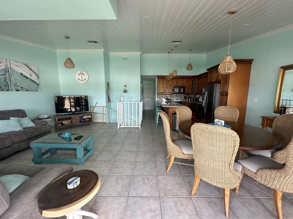 Upstairs living area with kitchen, dining table and outdoor balcony. 
