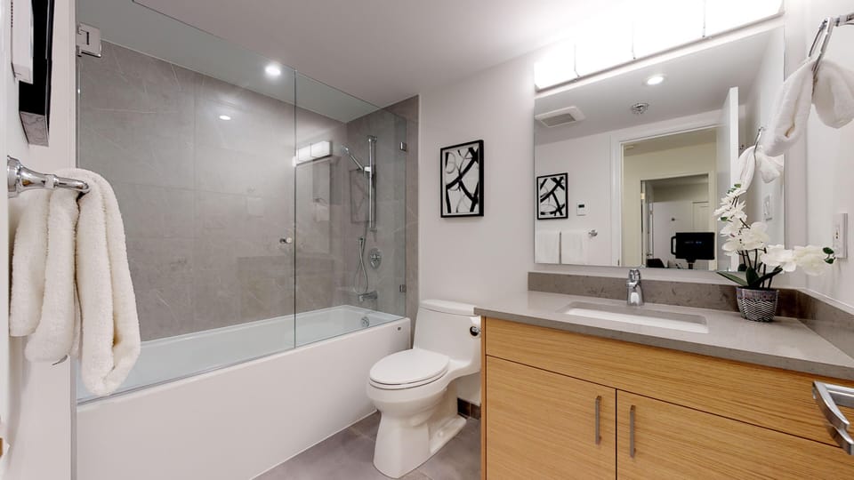 Shared bathroom with bathtub with overhead shower and single vanity