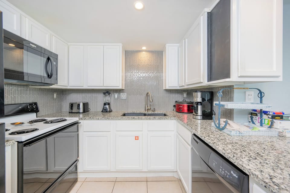 Kitchen featuring sleek granite countertops, black appliances, and modern cabinetry for a delightful cooking experience
