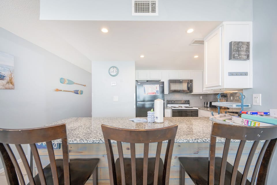 Bright kitchen and a cozy breakfast bar with stools perfect for morning coffee