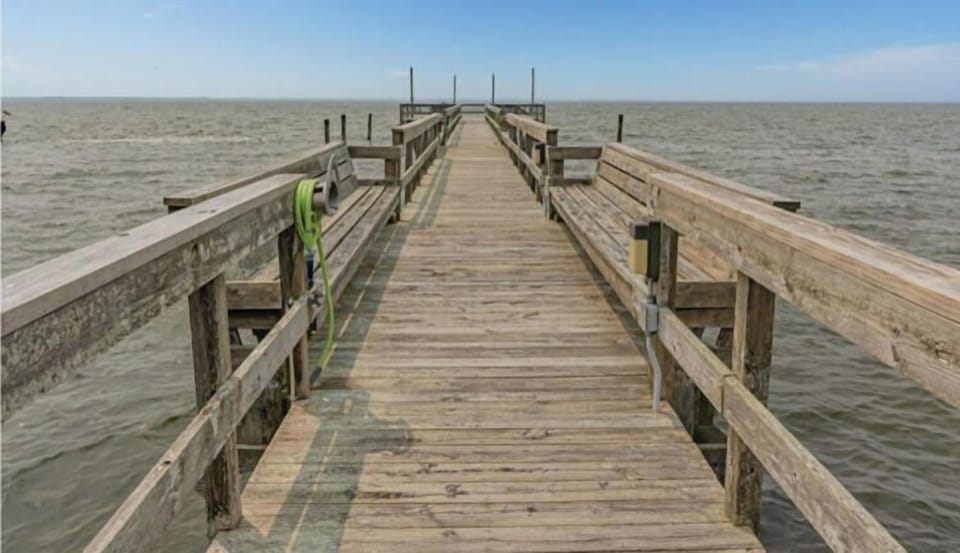 Ships Watch Community Sound Pier extends over calm coastal waters, offering direct waterfront access and scenic views of the surrounding natural landscape.