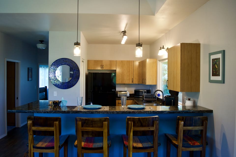 Full kitchen with quartz counter tops & bar with teak bar stools