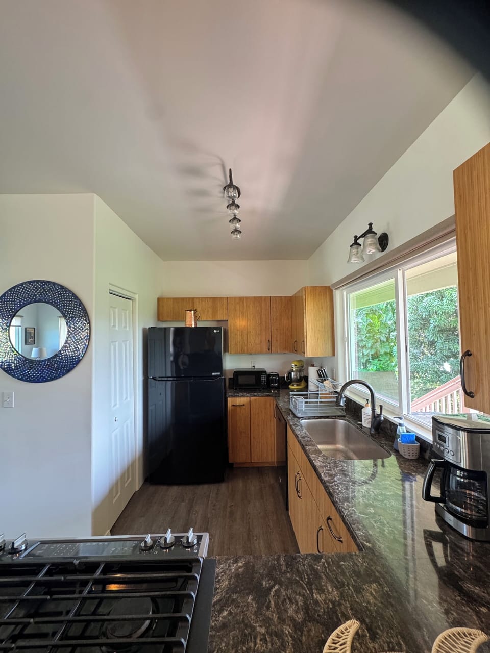 View of kitchen length with fridge & freezer view, sink & dishwasher on right