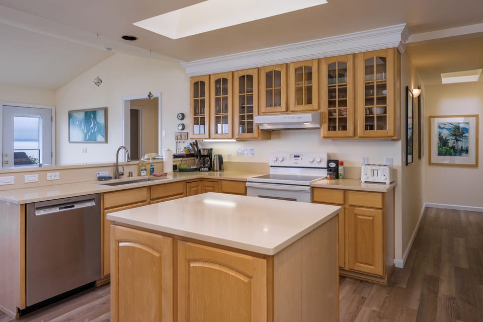 Your spacious kitchen awaits with beautiful wood cabinetry, modern appliances, and a bright island perfect for preparing meals or gathering with loved ones.