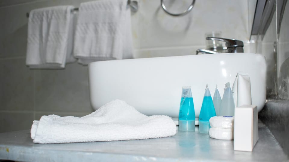 Shower, rainfall showerhead, slippers, towels