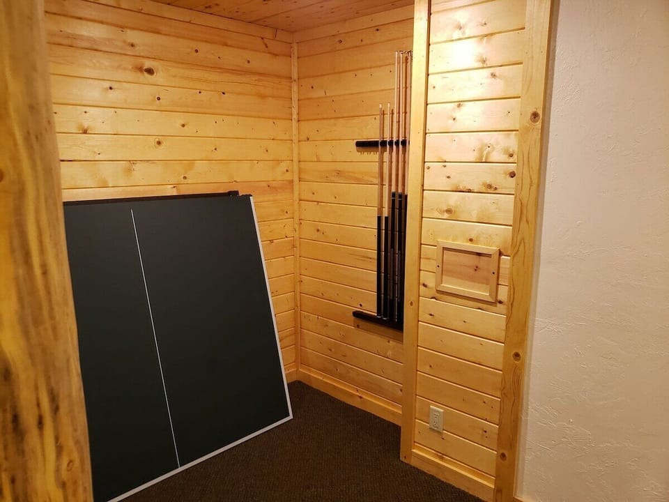 Basement at Yellowstone Cabin. The pool table has a ping pong table top and there are built in shelves for games and such.