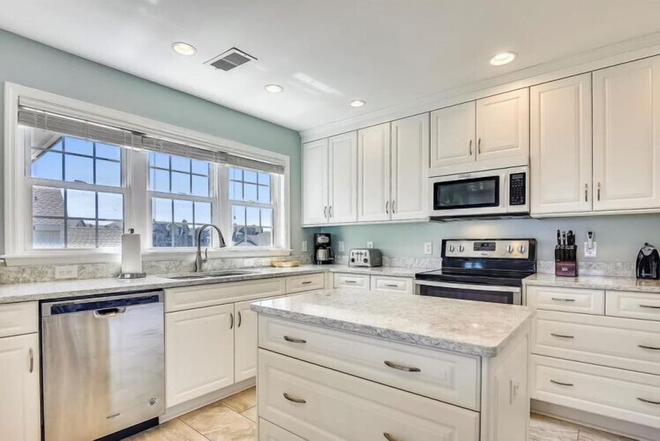 Your fully equipped kitchen awaits with bright white cabinetry, stainless steel appliances, and a central island for meal prep. Granite countertops and ample storage make cooking feel effortless and inviting.