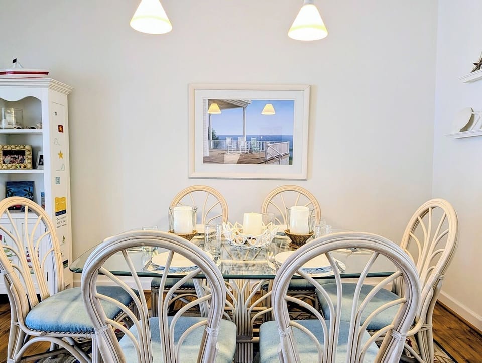 618 Driftwood Court - Sophisticated Dining Space - This view emphasizes the coastal-inspired decor, including light blue accents and a traditional white hutch for storage and display. The warm wood flooring adds a touch of natural elegance to the bright room.