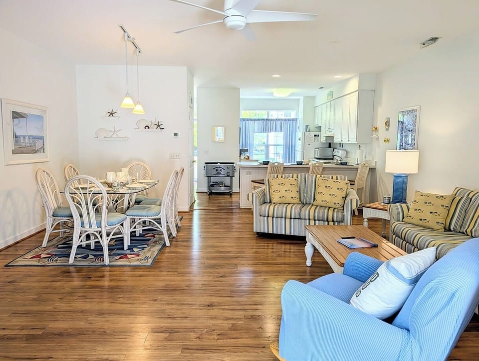618 Driftwood Court - Formal Dining for Entertaining - The open floor plan seamlessly connects the dining area, featuring a white wooden table set, to the kitchen and living spaces. This layout is ideal for hosting family dinners and social gatherings.